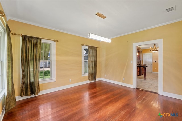 spare room with hardwood / wood-style floors and crown molding