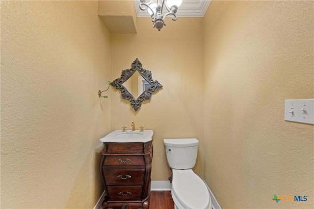 bathroom with toilet, wood-type flooring, crown molding, and vanity