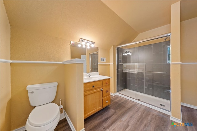 bathroom featuring a shower with door, hardwood / wood-style floors, vanity, lofted ceiling, and toilet