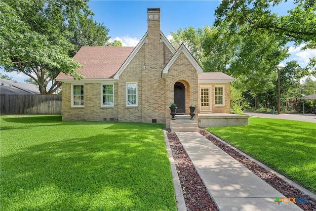 tudor-style house featuring a front yard