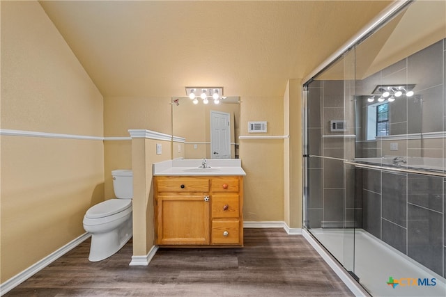 bathroom featuring walk in shower, vanity, a textured ceiling, hardwood / wood-style flooring, and toilet