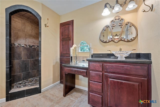 bathroom featuring vanity and tiled shower