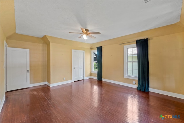 unfurnished room with dark wood-type flooring, a textured ceiling, and ceiling fan