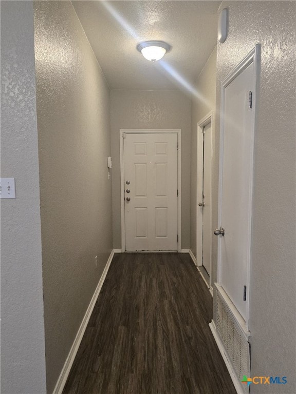 8630 Hogan Rd, Temple, TX 76502 - hall with wood finished floors, a textured wall, baseboards, and a textured ceiling