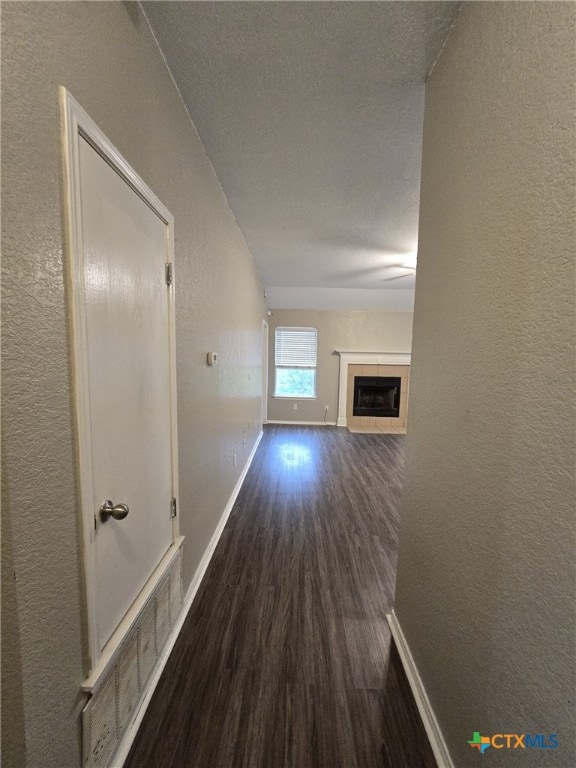 8630 Hogan Rd, Temple, TX 76502 - hall with baseboards, dark wood-style floors, and a textured wall
