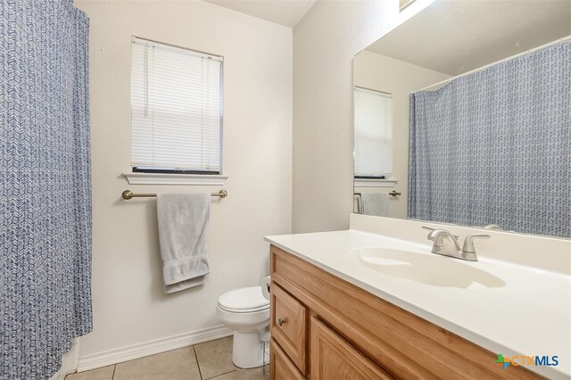 bathroom with tile patterned flooring, vanity, and toilet