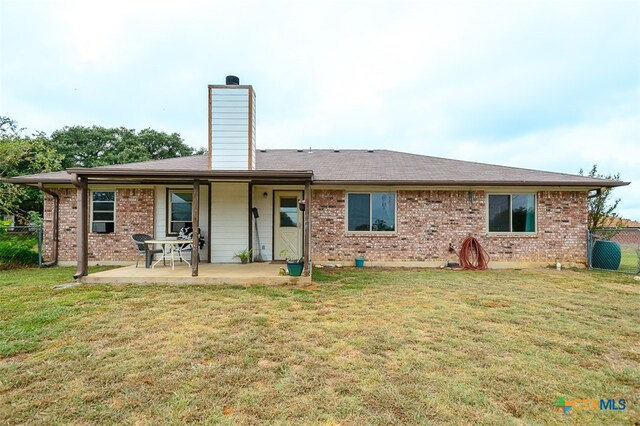 back of property featuring a lawn and a patio area