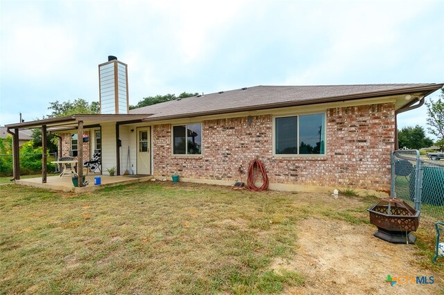 back of house with a patio, a yard, and an outdoor fire pit