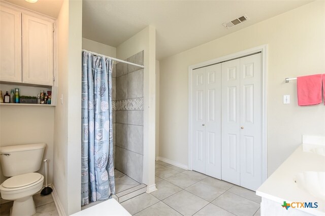 bathroom featuring toilet, a shower with curtain, vanity, and tile patterned floors