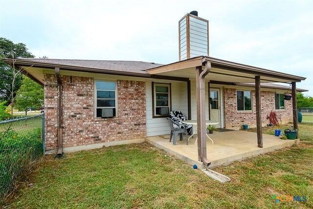 rear view of house with a yard and a patio area