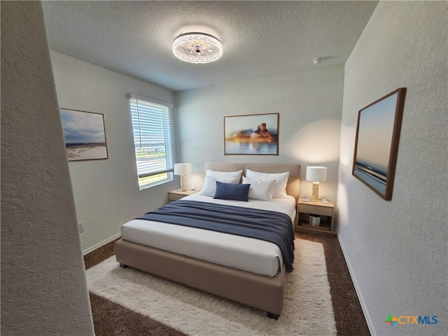 bedroom featuring carpet flooring and a textured ceiling