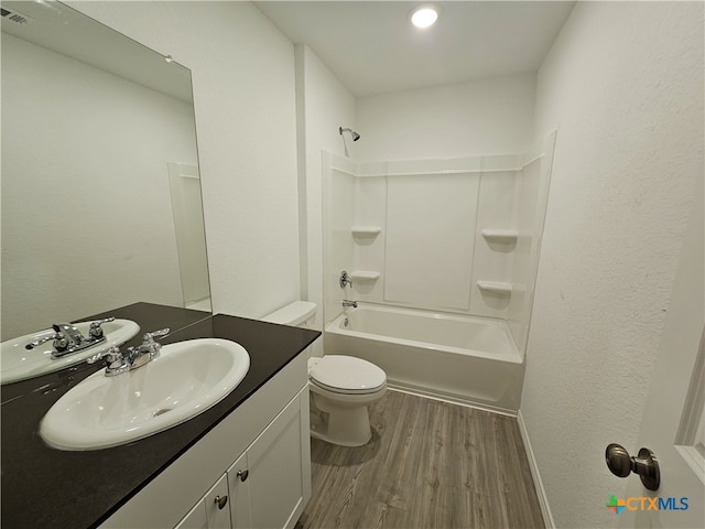 full bathroom featuring washtub / shower combination, hardwood / wood-style floors, vanity, and toilet