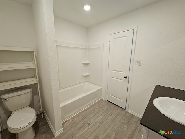 full bathroom with washtub / shower combination, wood-type flooring, vanity, and toilet