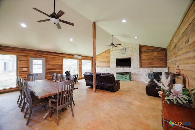 dining space with an AC wall unit, wood walls, ceiling fan, and vaulted ceiling