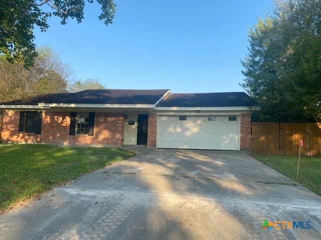 ranch-style home with a garage and a front lawn