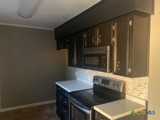 kitchen featuring appliances with stainless steel finishes and ornamental molding