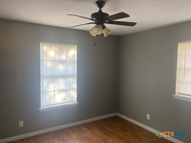 unfurnished room with hardwood / wood-style floors and ceiling fan