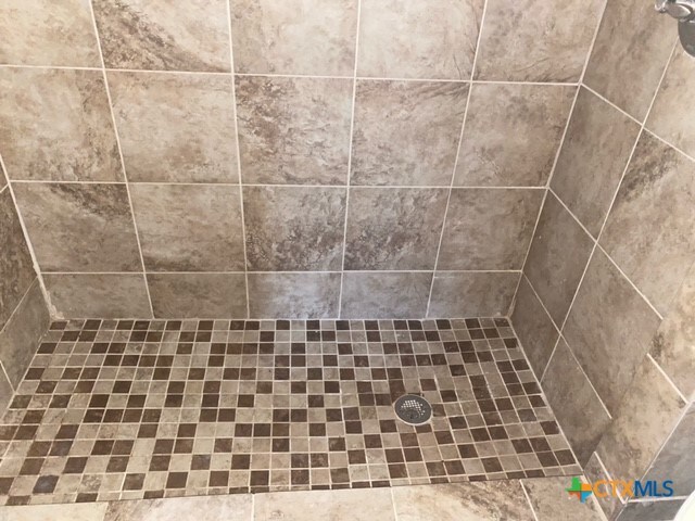 interior details with a tile shower