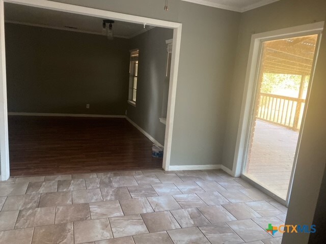 unfurnished room with light wood-type flooring and crown molding