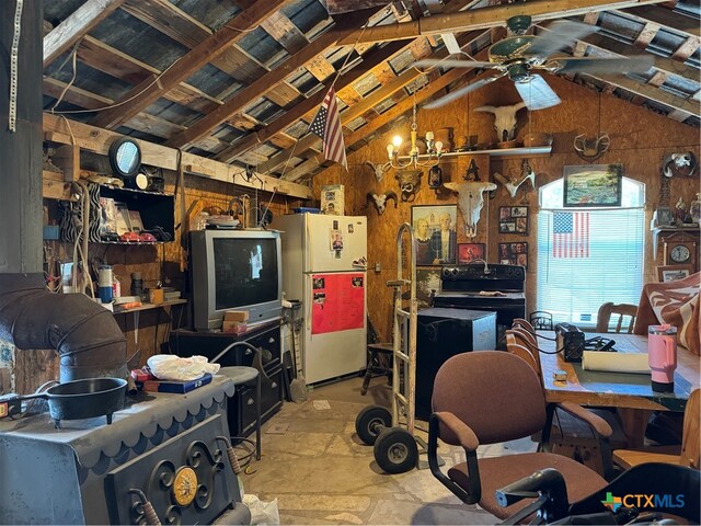 kitchen with white refrigerator, wood walls, lofted ceiling, and ceiling fan