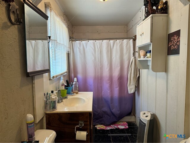 bathroom with toilet, a shower with curtain, vanity, and tile patterned flooring