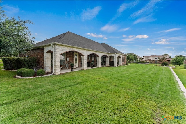 back of house featuring a patio area and a lawn