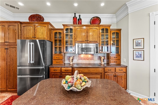 kitchen with backsplash, appliances with stainless steel finishes, and crown molding