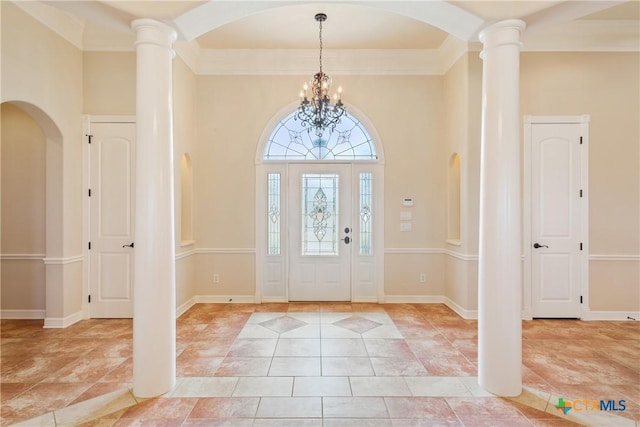 foyer featuring ornate columns, light tile patterned floors, baseboards, and a notable chandelier