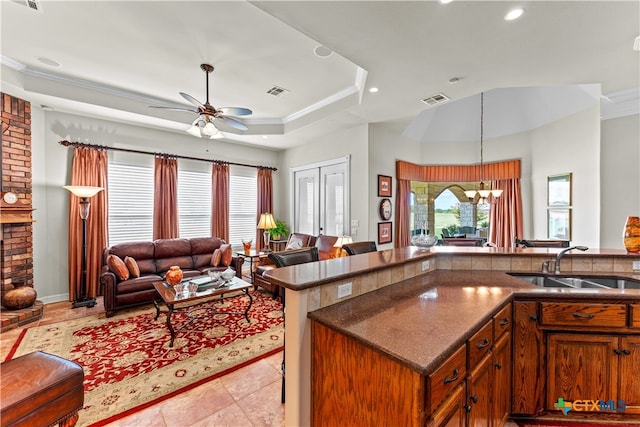 kitchen featuring ornamental molding, light tile patterned floors, pendant lighting, sink, and ceiling fan with notable chandelier