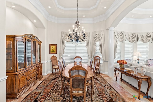 dining area featuring a high ceiling, a chandelier, ornamental molding, and decorative columns