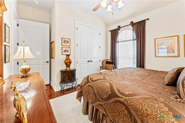 bedroom featuring a closet, wood-type flooring, vaulted ceiling, and ceiling fan