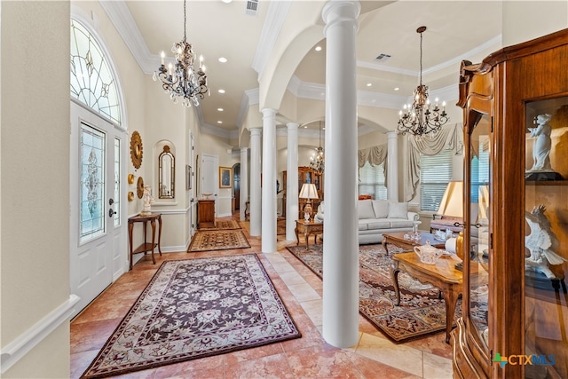 entrance foyer featuring decorative columns, a towering ceiling, a notable chandelier, and crown molding