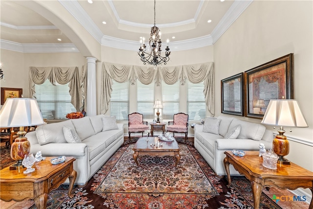 living room with decorative columns, a chandelier, crown molding, and plenty of natural light