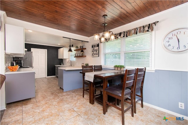 4512 Briar Cliff Rd, Temple, TX 76502 - dining room with wooden ceiling, a chandelier, a wainscoted wall, light tile patterned flooring, and crown molding