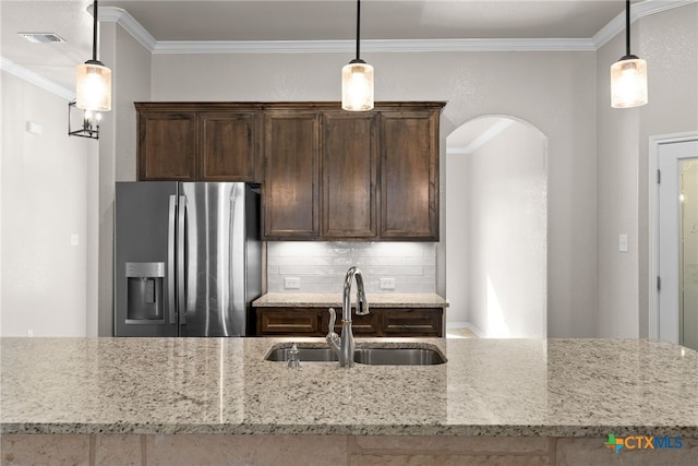 kitchen featuring crown molding, stainless steel fridge, a sink, and dark brown cabinets