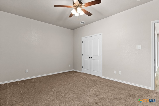 unfurnished room with ceiling fan, carpet flooring, visible vents, and baseboards