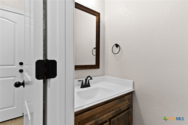 bathroom featuring a textured wall and vanity