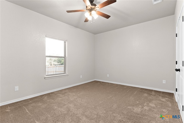 spare room featuring carpet floors, ceiling fan, visible vents, and baseboards