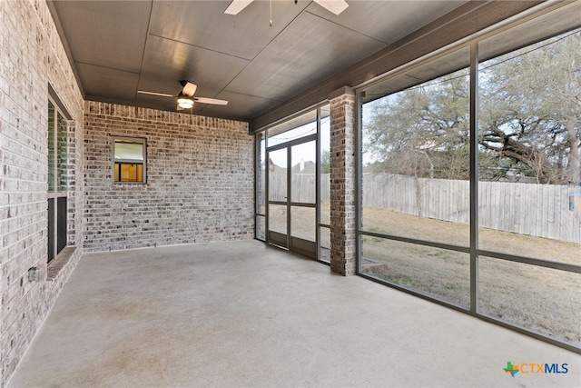 unfurnished sunroom featuring ceiling fan