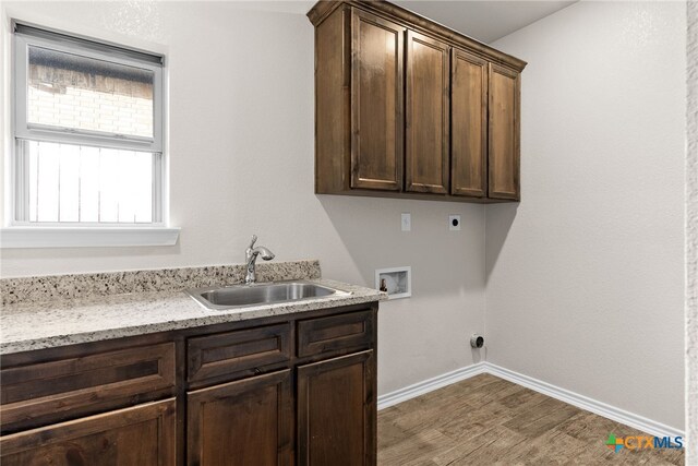 laundry room featuring hookup for a washing machine, hookup for an electric dryer, a sink, baseboards, and cabinet space