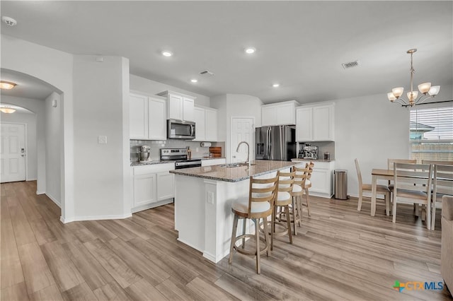 2026 Bee Creek Loop, Copperas Cove, TX 76522 - kitchen with appliances with stainless steel finishes, arched walkways, a breakfast bar, a sink, and tasteful backsplash