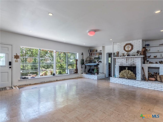 1000 Advance St, San Marcos, TX 78666 - unfurnished living room featuring recessed lighting, cooling unit, and a brick fireplace