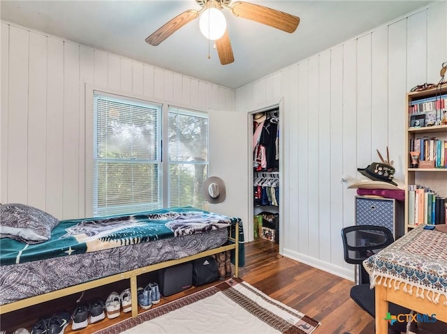 1000 Advance St, San Marcos, TX 78666 - bedroom featuring ceiling fan, a closet, a spacious closet, wood finished floors, and wood walls