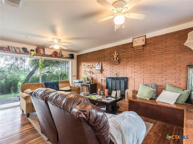 1000 Advance St, San Marcos, TX 78666 - living area featuring brick wall, visible vents, a ceiling fan, and wood finished floors