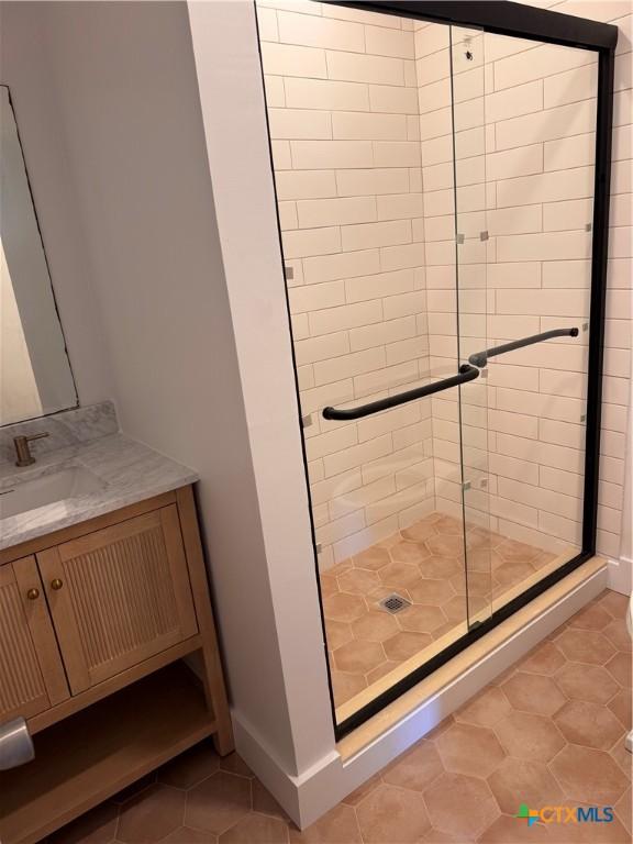 1000 Advance St, San Marcos, TX 78666 - bathroom with tile patterned floors, baseboards, vanity, and a shower stall