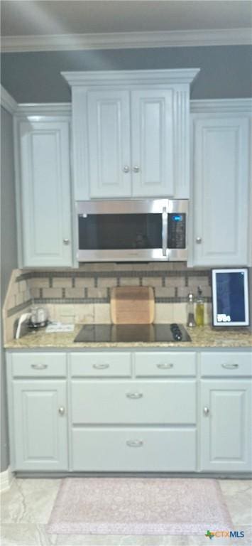 1122 Windy Hill Rd, Harker Heights, TX 76548 - kitchen featuring stainless steel microwave, black electric stovetop, decorative backsplash, crown molding, and light countertops