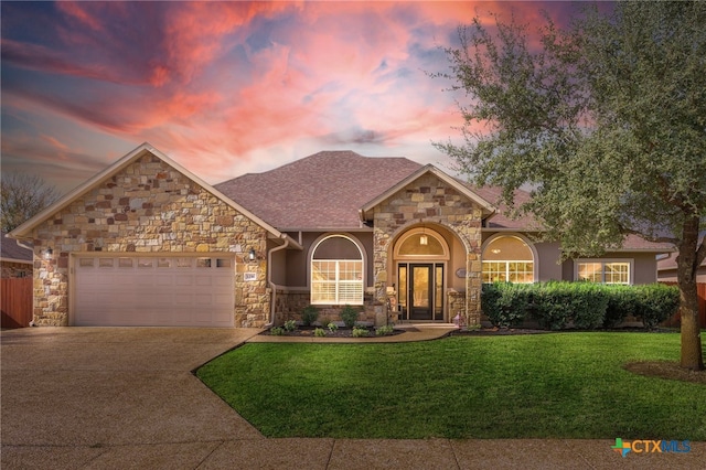 view of front of property with a garage and a lawn