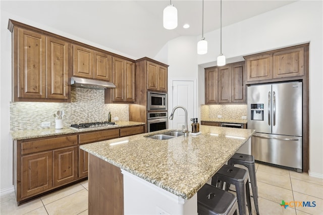 kitchen featuring under cabinet range hood, light tile patterned floors, appliances with stainless steel finishes, and light stone countertops