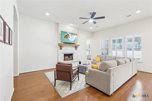 living room featuring baseboards, ceiling fan, recessed lighting, a fireplace, and wood finished floors