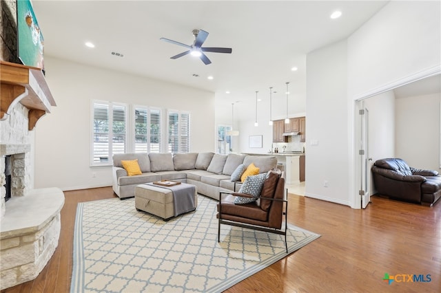 living area featuring recessed lighting, a fireplace, light wood-type flooring, and ceiling fan